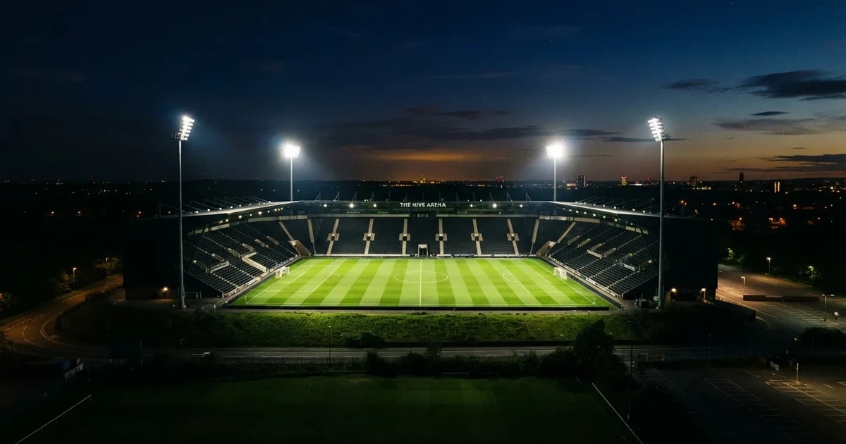 Ein Stadion bei Nacht unter Flutlicht aus der Ferne gesehen, der Rasen ist hell erleuchtet, keine erkennbaren Personen.